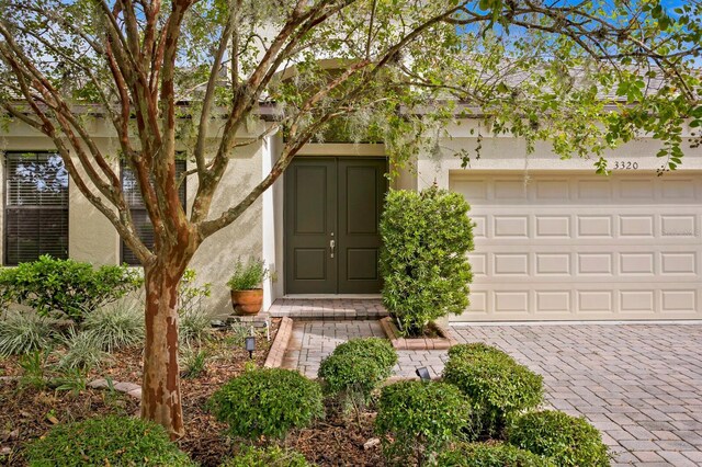 3320 Majestic View Dr, Lutz, FL 33558 - doorway to property with driveway, an attached garage, and stucco siding