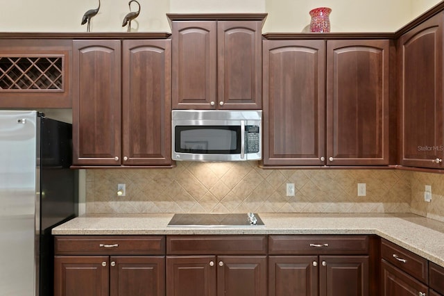 3320 Majestic View Dr, Lutz, FL 33558 - kitchen with appliances with stainless steel finishes, tasteful backsplash, and dark brown cabinets
