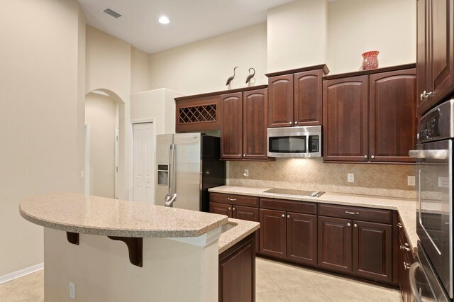 3320 Majestic View Dr, Lutz, FL 33558 - kitchen with stainless steel appliances, light tile patterned flooring, a kitchen island, and dark brown cabinets