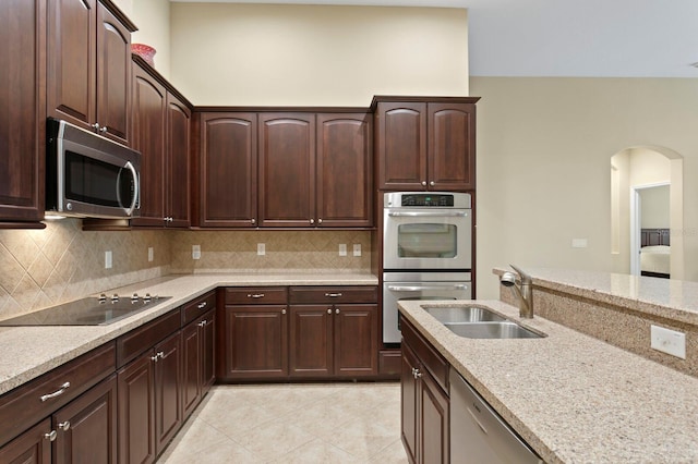 3320 Majestic View Dr, Lutz, FL 33558 - kitchen with appliances with stainless steel finishes, a sink, tasteful backsplash, and arched walkways