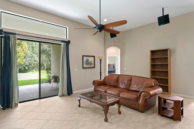 3320 Majestic View Dr, Lutz, FL 33558 - living area with a ceiling fan, arched walkways, light tile patterned floors, baseboards, and a high ceiling