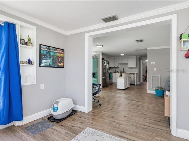 interior space featuring crown molding and light wood-type flooring