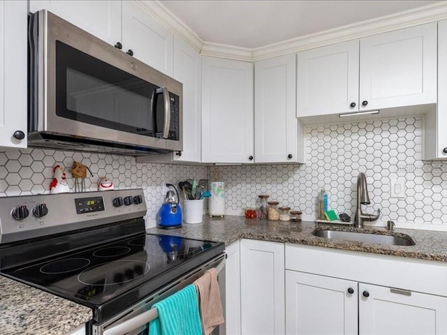 kitchen featuring appliances with stainless steel finishes, white cabinetry, and tasteful backsplash