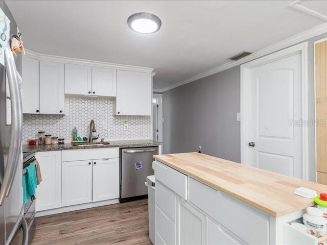 kitchen with sink, appliances with stainless steel finishes, hardwood / wood-style flooring, and white cabinetry