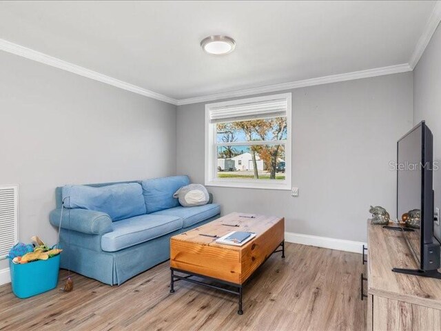 living room featuring light hardwood / wood-style floors and ornamental molding