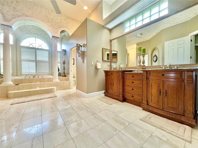 bathroom featuring a high ceiling, vanity, ornate columns, and ceiling fan