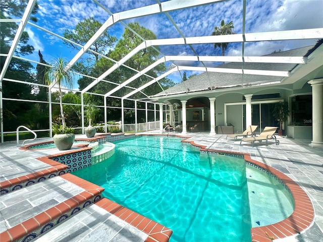 view of swimming pool with a lanai, a patio area, and an in ground hot tub