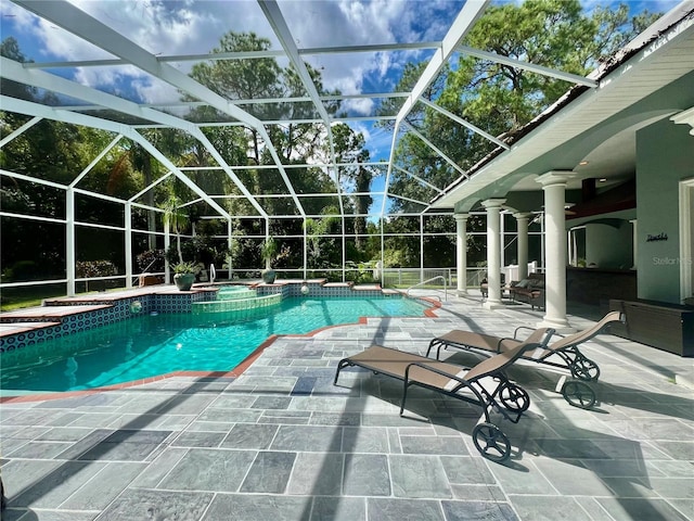 view of swimming pool with glass enclosure, an in ground hot tub, and a patio