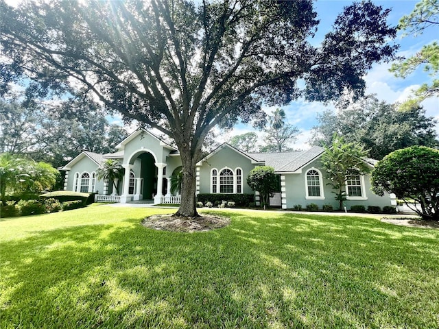 single story home with a front yard and covered porch