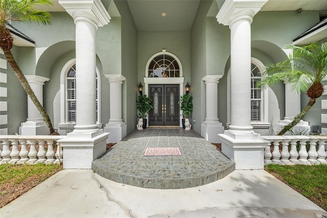168 Rue Des Chateaux, Tarpon Springs, FL 34688 - view of exterior entry featuring french doors, stucco siding, and covered porch