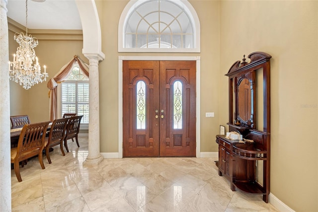 168 Rue Des Chateaux, Tarpon Springs, FL 34688 - entrance foyer featuring a chandelier, a high ceiling, marble finish floors, and decorative columns