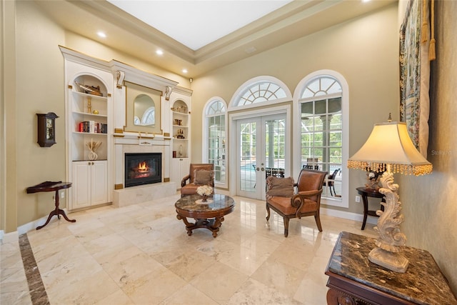 168 Rue Des Chateaux, Tarpon Springs, FL 34688 - sitting room with french doors, recessed lighting, built in shelves, light marble finish flooring, and a fireplace