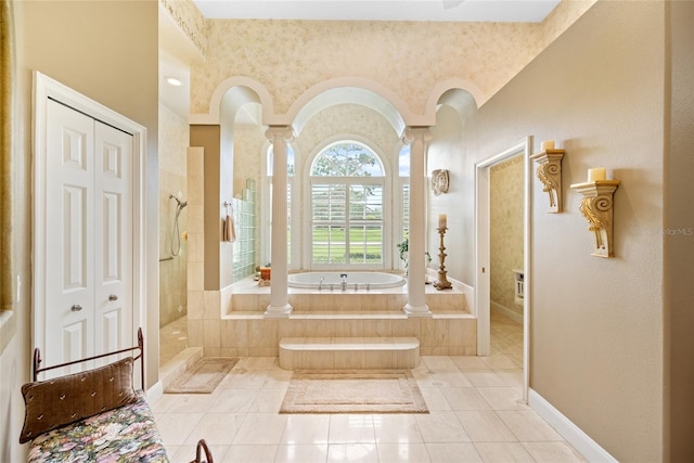 168 Rue Des Chateaux, Tarpon Springs, FL 34688 - bathroom featuring a bath, decorative columns, a tile shower, and tile patterned flooring