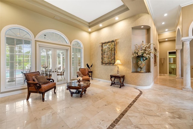 168 Rue Des Chateaux, Tarpon Springs, FL 34688 - living area featuring french doors, decorative columns, ornamental molding, a towering ceiling, and light marble finish flooring