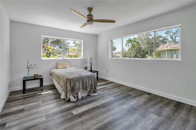 bedroom with dark hardwood / wood-style flooring and ceiling fan