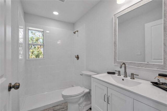 bathroom featuring vanity, a shower, and toilet