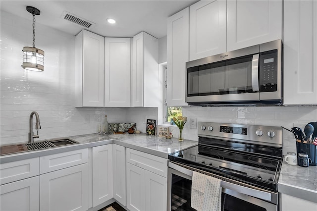 kitchen featuring appliances with stainless steel finishes, sink, white cabinets, and backsplash