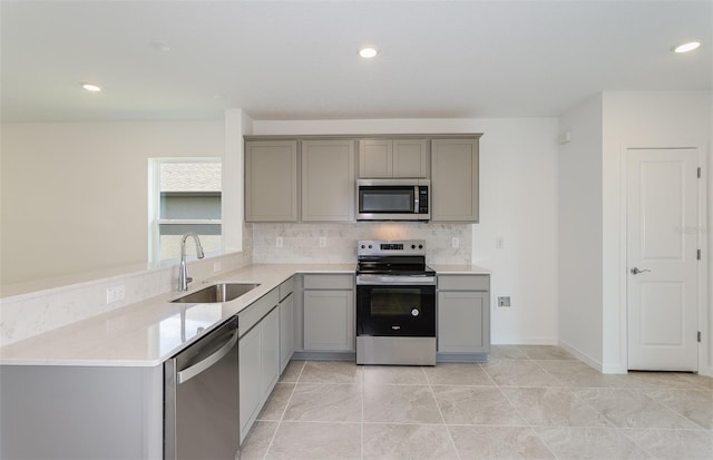 kitchen featuring gray cabinets, light tile patterned floors, sink, and appliances with stainless steel finishes