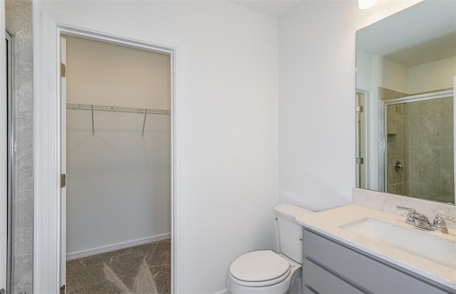 bathroom with vanity, toilet, and a shower with shower door