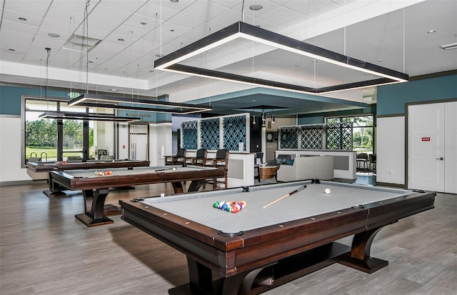 recreation room with a towering ceiling, wood-type flooring, and billiards