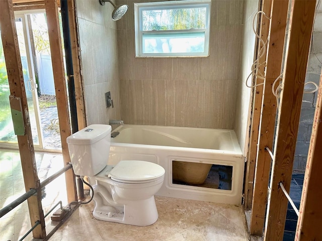 bathroom featuring shower / bathing tub combination, a wealth of natural light, and toilet