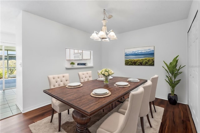 dining room featuring dark wood-type flooring and a chandelier