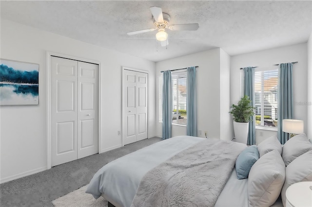 bedroom featuring multiple closets, multiple windows, carpet floors, and ceiling fan