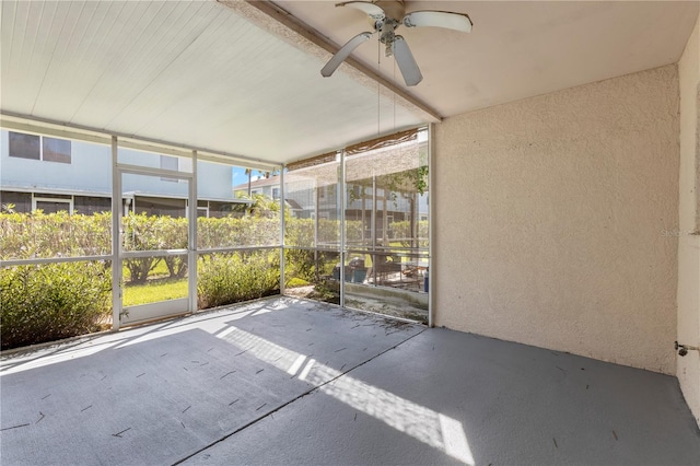 unfurnished sunroom featuring ceiling fan and a wealth of natural light