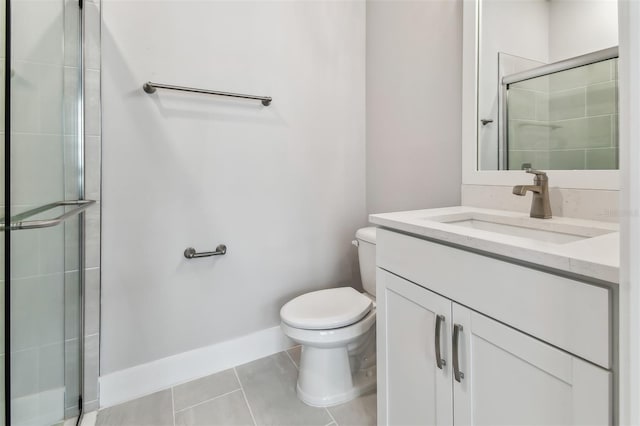 bathroom featuring tile patterned floors, vanity, toilet, and a shower with door