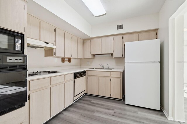 kitchen with white appliances, light wood-type flooring, sink, and light brown cabinets