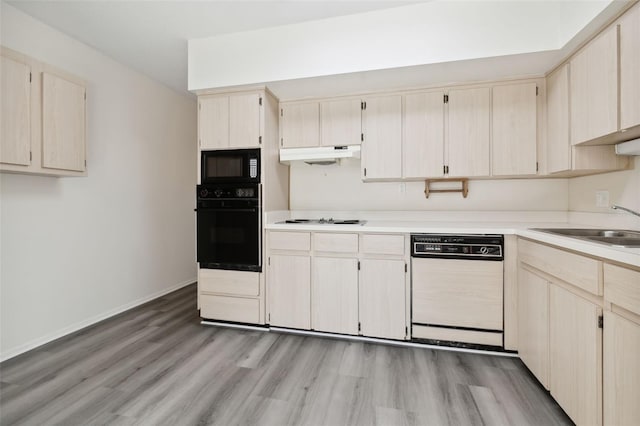 kitchen with sink, black appliances, light hardwood / wood-style flooring, and light brown cabinets