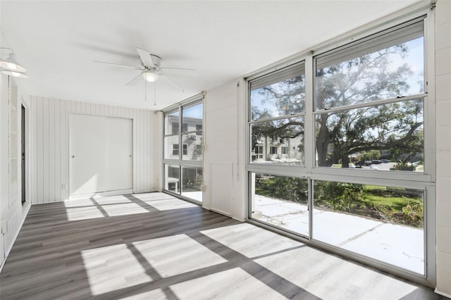 unfurnished sunroom featuring ceiling fan