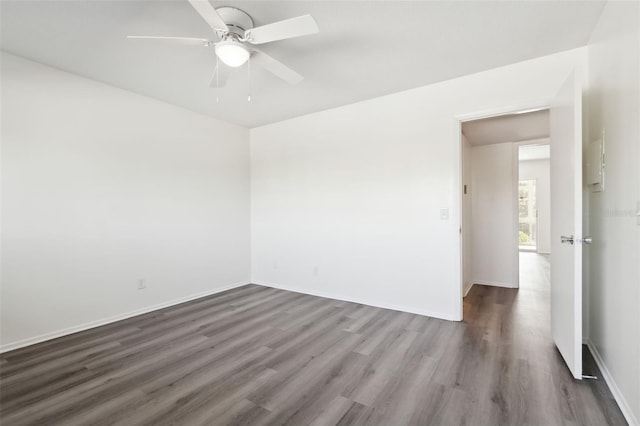 spare room featuring dark wood-type flooring and ceiling fan