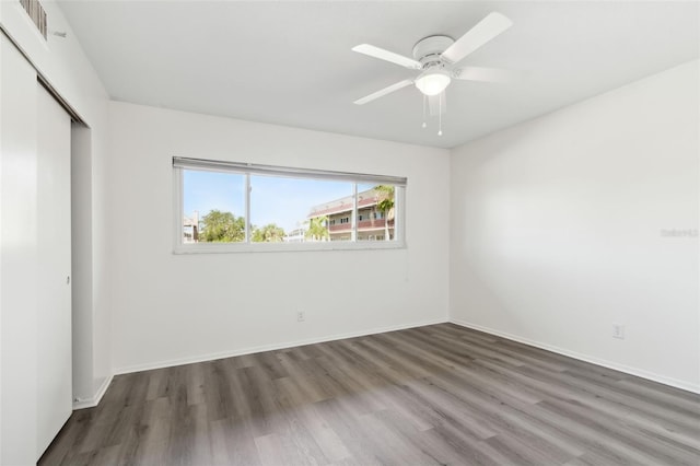 unfurnished bedroom with dark hardwood / wood-style floors, a closet, and ceiling fan