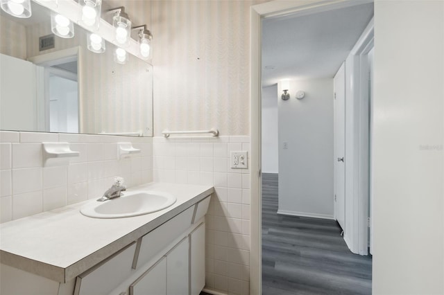 bathroom featuring vanity, tile walls, and hardwood / wood-style flooring