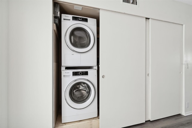 laundry area featuring light hardwood / wood-style flooring and stacked washer and clothes dryer