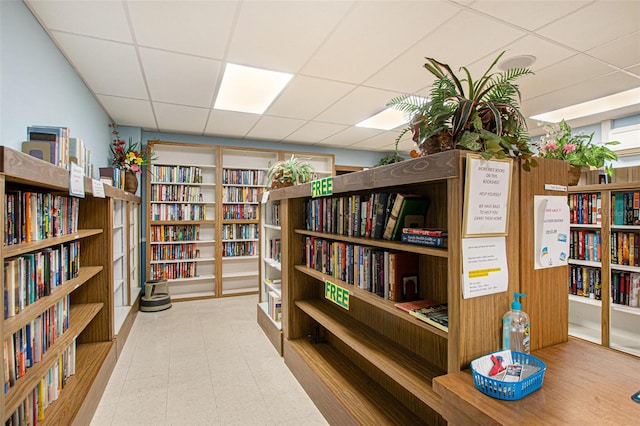 interior space with wood walls and a drop ceiling