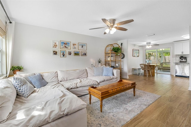 living room featuring wood-type flooring and ceiling fan