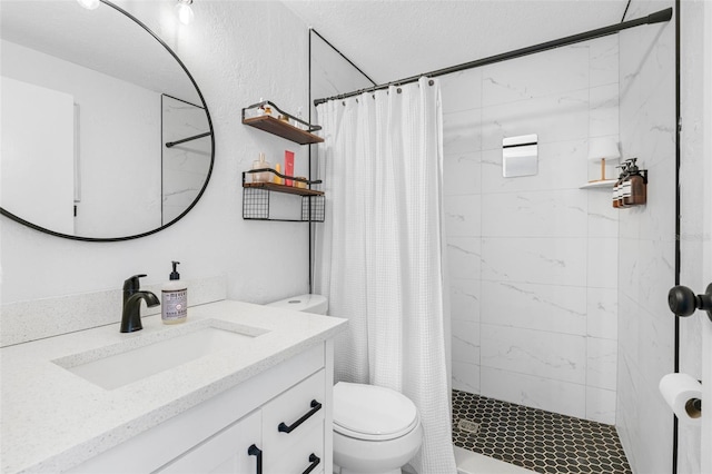 bathroom with a shower stall, toilet, and vanity