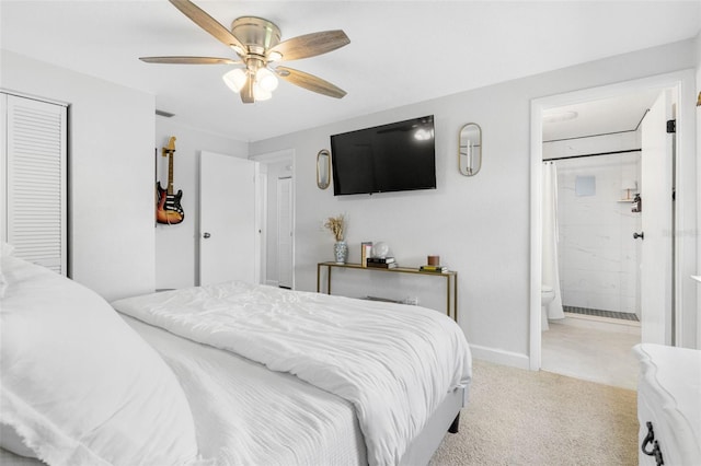 bedroom with ensuite bathroom, carpet floors, a ceiling fan, baseboards, and a closet