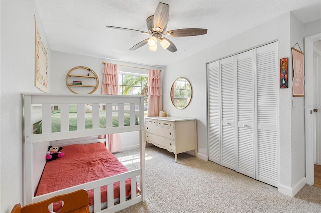 bedroom featuring baseboards, a closet, a ceiling fan, and light colored carpet