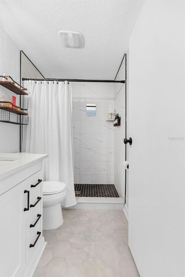 full bath featuring a stall shower, visible vents, toilet, a textured ceiling, and vanity