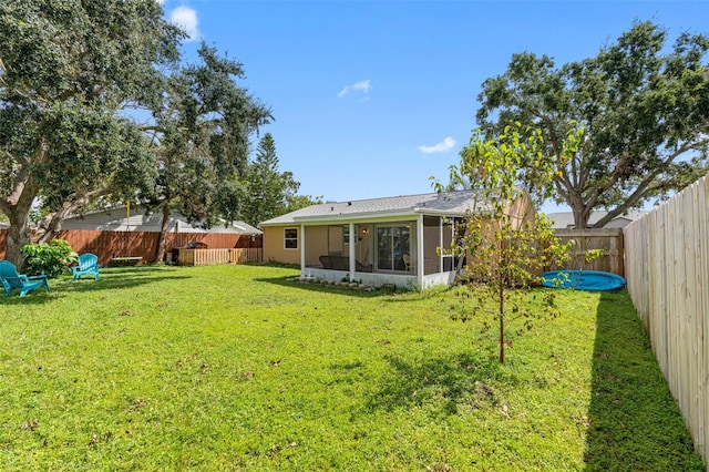 view of yard with a fenced backyard and a sunroom