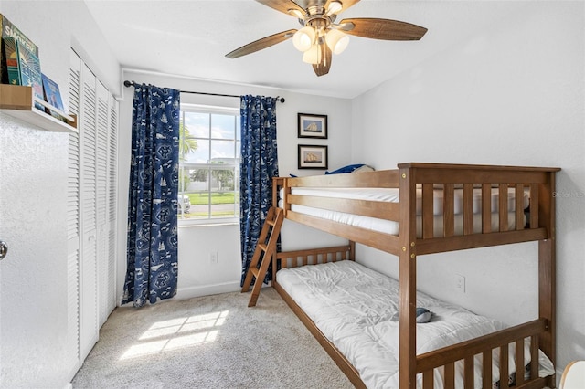 bedroom with carpet floors, ceiling fan, baseboards, and a closet