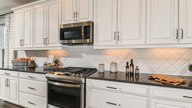 kitchen featuring decorative backsplash, white cabinetry, and appliances with stainless steel finishes