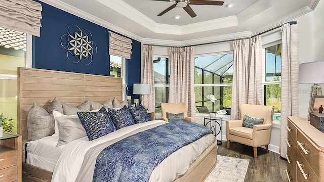 bedroom with a raised ceiling, ceiling fan, crown molding, and dark wood-type flooring