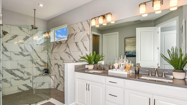 bathroom with vanity and tiled shower