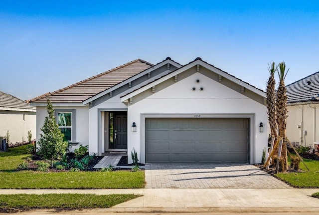 ranch-style home featuring central AC, a garage, and a front lawn