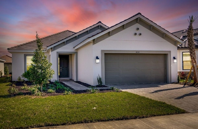 view of front of property with a garage and a yard