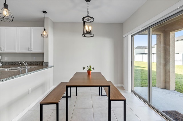 tiled dining space featuring sink and a chandelier